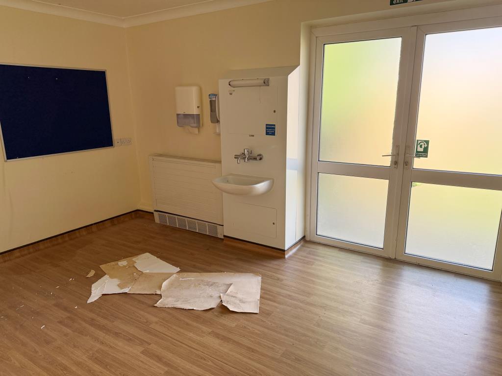 Lot: 168 - FORMER NHS PREMISES WITH POTENTIAL FOR DEVELOPMENT - Consulting room with sink and doors to rear garden